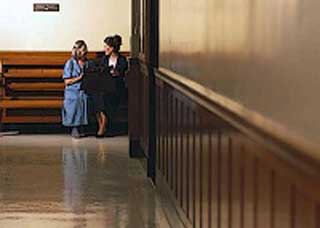 Two women speaking in a courthouse hallway