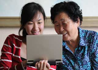 Image of a grandma and granddaughter reading a computer screen