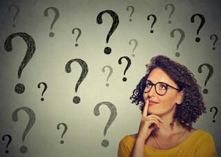 Woman in glasses with question marks in the background