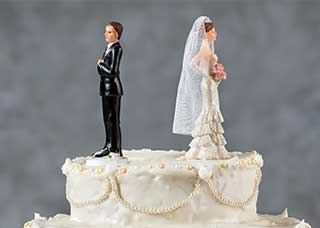 Image of a bride and groom wedding cake toppers with their backs to each other