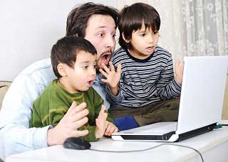 Image of a man with two sons looking at a laptop